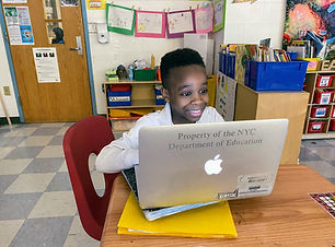 One student working on a laptop in a classroom.