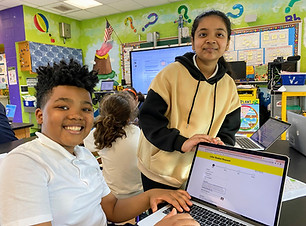 Two students working collaborative on a laptop.