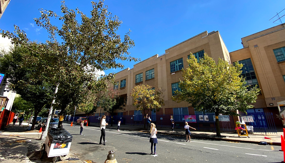 Students playing games outside of the main entrace of the school.